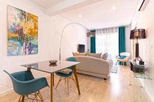 uma sala de estar com uma mesa e cadeiras e um sofá em Genteel Home Encarnación em Sevilha