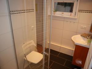 a shower in a bathroom with a chair and a sink at Haus-Wolter in Goslar +17 photos