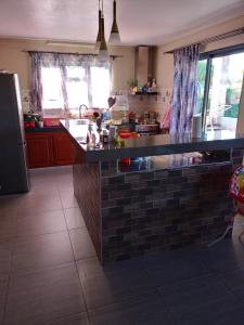 a kitchen with a brick counter top in a kitchen at 3 bedrooms bungalow with jacuzzi enclosed garden and wifi at Chemin Grenier 2 km away from the beach in Chemin Grenier