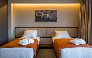 2 łóżka w pokoju hotelowym z ręcznikami w obiekcie Bridge Hotel w mieście Tbilisi City