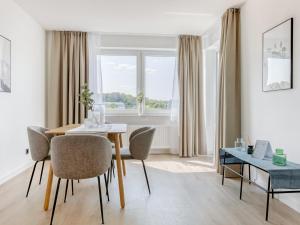 a dining room with a table and chairs and a window at limehome Wolfsburg Porschestraße in Wolfsburg