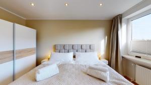 ein Schlafzimmer mit einem großen Bett und einem Fenster in der Unterkunft Ferienwohnung 3-Zimmer, 74 qm 3 Minuten zum Strand und Zentrum WHG Timme 11 in Timmendorfer Strand