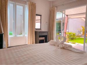 a bedroom with a bed with two swans on it at Dang Sea Beach Resort - SHA in Nai Yang Beach