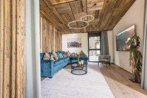 a living room with a blue couch and a table at Perfect Lodgings Panorama in Hart im Zillertal