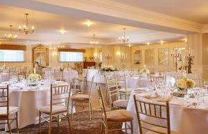 un set para una boda en una habitación con mesas y sillas en Bellbridge House Hotel en Spanish Point