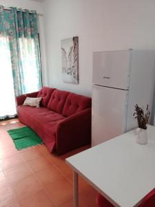 a living room with a red couch and a refrigerator at Apartamento en puerta valle Ricote y Archena in Villanueva de Río Segura