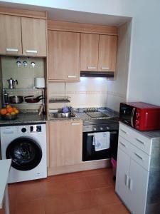 a kitchen with a stove and a washing machine at Apartamento en puerta valle Ricote y Archena in Villanueva de Río Segura