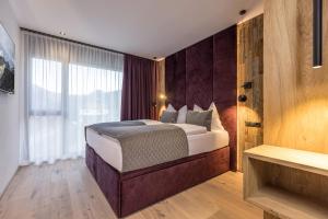 a bedroom with a bed and a large window at Perfect Lodgings Panorama in Hart im Zillertal