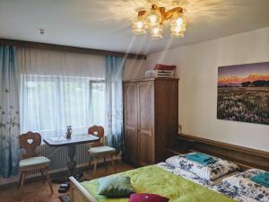 sypialnia z 2 łóżkami, stołem i oknem w obiekcie Montahaus w mieście Vandans