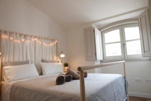 een slaapkamer met een wit bed en een raam bij Malagaflat Rooftop Apartment City Center in Málaga