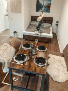 a room with a table with glasses and a bed at Ferienwohnung Paula Winterberg in Winterberg