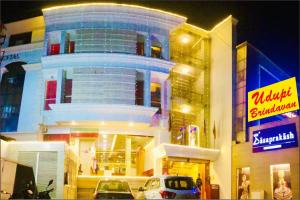 un gran edificio con coches estacionados frente a él en Hotel Dasaprakash, en Agra