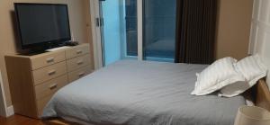 a bedroom with a bed with a flat screen tv at Ocean View in Geoje 