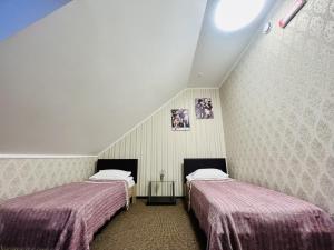two beds sitting in a room with a attic at Готель Лаванда in Khmelʼnytsʼkyy +24 photos