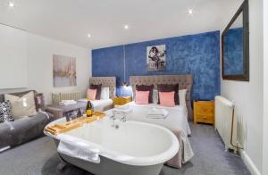 a bathroom with a tub and a bed and a couch at Converted Luxury Stables in Haxby