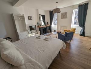 um quarto com uma cama branca e uma sala de estar em La Suite Gignac em Gignac