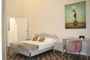 卡塔尼亞的住宿－DOMUS IOLE appartamento nel centro storico，卧室配有一张床,墙上挂有绘画作品