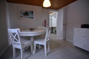 Un comedor con una mesa y sillas blancas. en Casa da Praya, en Horta