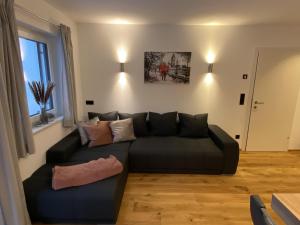 a living room with a black couch in a room at Seereith Apartments in Brixen im Thale