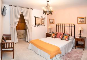 1 dormitorio con cama y lámpara de araña en Casa Ravel, en Silleda