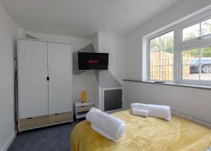 達寧頓堡的住宿－Donington Cottage Apt 4，卧室配有一张床,墙上配有电视。