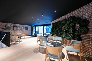 un restaurante con mesas y sillas y una pared de ladrillo en Staycity Aparthotels Dublin Mark Street en Dublín