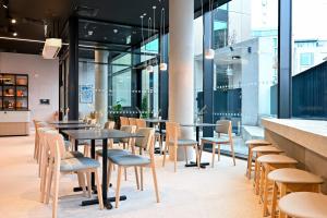 Staycity Aparthotels Dublin Mark Street في دبلن: مطعم بطاولات وكراسي ونوافذ