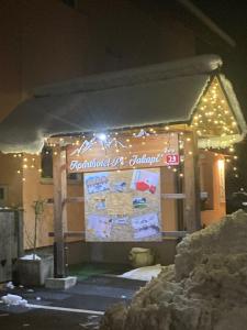a sign for a restaurant at night with lights at Aparthotel Pr' Jakapč' in Mojstrana