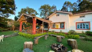 een huis met een tuin met houtblokken ervoor bij The Birdhouse Backpackers Hostel in Coonoor