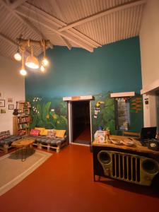 una sala de estar con una gran pintura en la pared en The Birdhouse Backpackers Hostel, en Coonoor