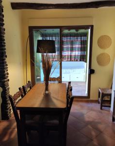 ein Esszimmer mit einem Tisch und einem Fenster in der Unterkunft Acogedor alojamiento Trevelez in Trevélez