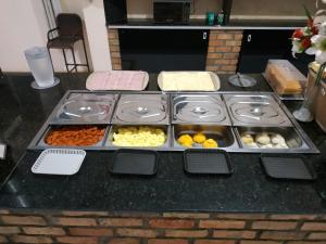 a table with trays of food on a counter at Hotel Lírio in Carolina