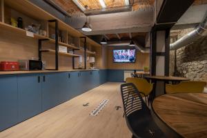 a room with a table and chairs and a tv at Font Andorra Hostel in La Massana