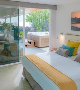 a bedroom with a large bed and a bath tub at Hyde Park Lane Villas in Puerto del Carmen