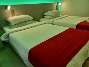 two beds with red and white sheets in a room at Beach Grand & Spa Premium in Hulhumale +30 photos