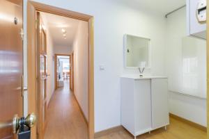 einen Flur mit einem weißen Schrank und einem Spiegel in der Unterkunft Cadillac lujo total sin pasar por un hotel in Cornellà de Llobregat