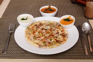 a table with a plate of food and bowls of soup at The Hawaii Comforts Panjim in Panaji