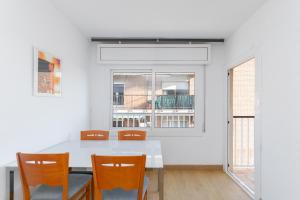 ein Esszimmer mit einem weißen Tisch und Stühlen in der Unterkunft Cadillac lujo total sin pasar por un hotel in Cornellà de Llobregat