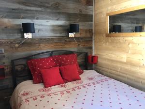 ヴァル・トランスにあるLes Appartements de Maéのベッドルーム1室(赤い枕のベッド1台付)
