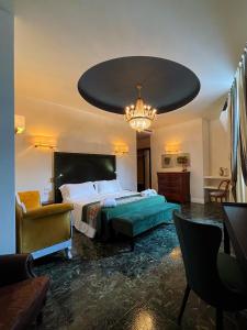 a bedroom with a large bed and a chandelier at Kemani Villa Sara Olbia in Olbia