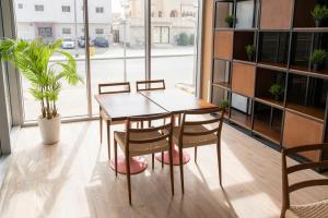 stół i krzesła w pokoju z dużym oknem w obiekcie Dara Al Rayan w Rijadzie