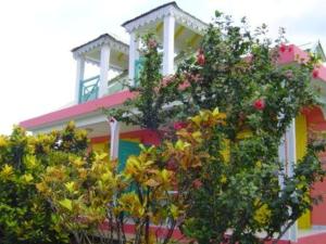 a colorful house with trees in front of it at Maison agréable Sainte-Rose + Piscine in Sainte-Rose +5 photos