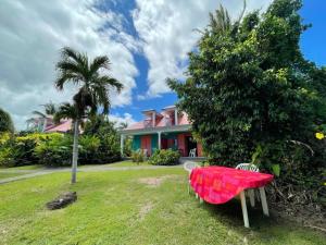 a table and chairs in front of a house at Maison avec piscine à Sainte-Rose in Sainte-Rose +7 photos