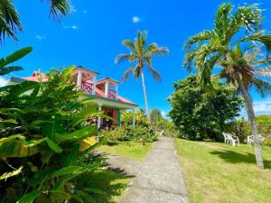 a house on the beach with palm trees at Maison avec piscine à Sainte-Rose in Sainte-Rose