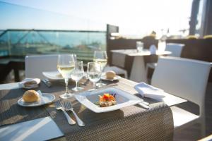 een tafel met een bord eten en wijnglazen bij Iberostar Bouganville Playa in Adeje