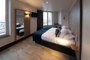 a hotel room with a bed and a large mirror at Hôtel Nancy Gare-Congrés in Nancy