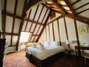 a bedroom with a large bed in a room with wooden ceilings at Dartington Hall in Totnes