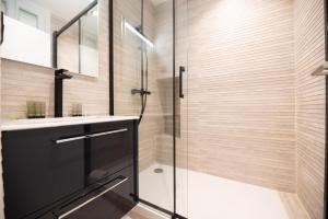 a bathroom with a glass shower and a sink at MBM - Michelis in Neuilly-sur-Seine