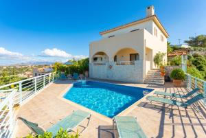 a villa with a swimming pool on a balcony at Villa Selini in Roussospítion