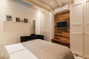 a bedroom with a bed and a tv on a brick wall at Leidse Square 5 star Luxury Apartment in Amsterdam
